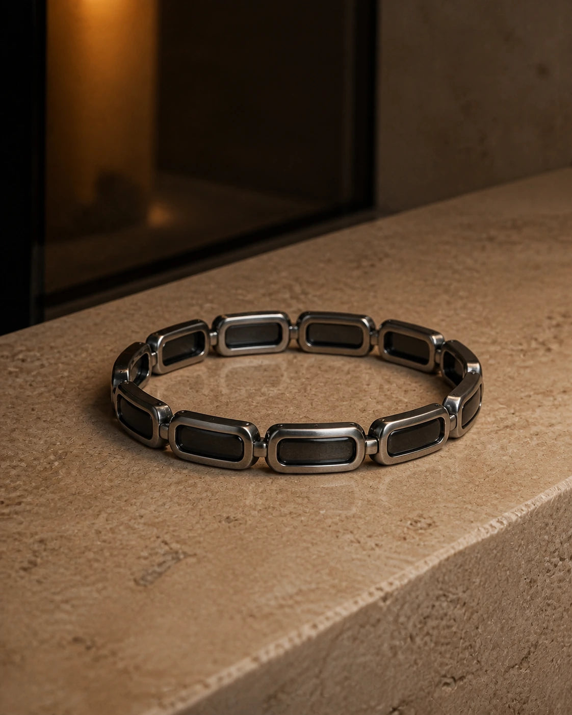 DARENZ Continuum Link Bracelet still life on charcoal stone with dark timber and controlled evening light
