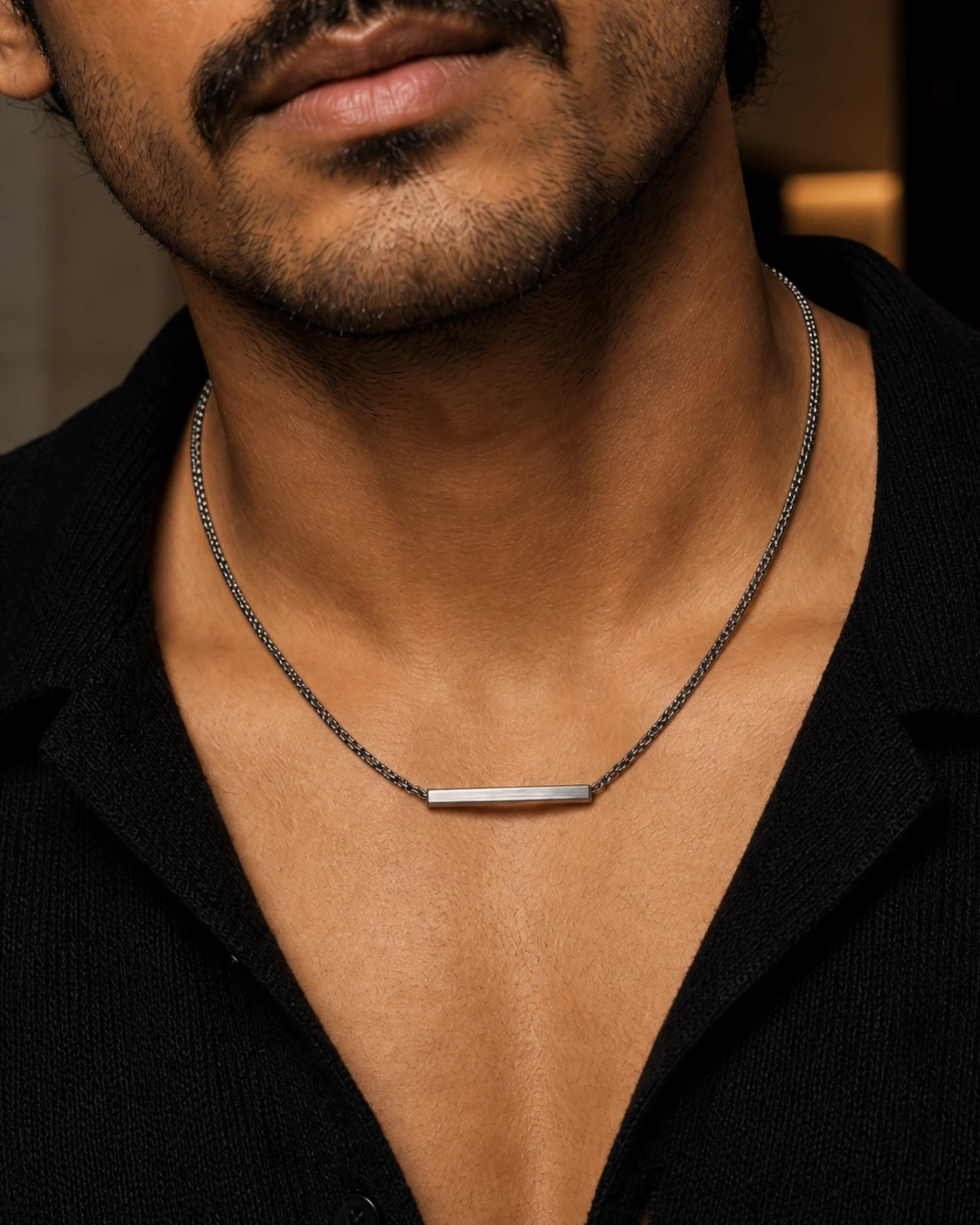 Macro photograph of the DARENZ Em Dash Chain, revealing the close dark links and elongated polished centre bar
