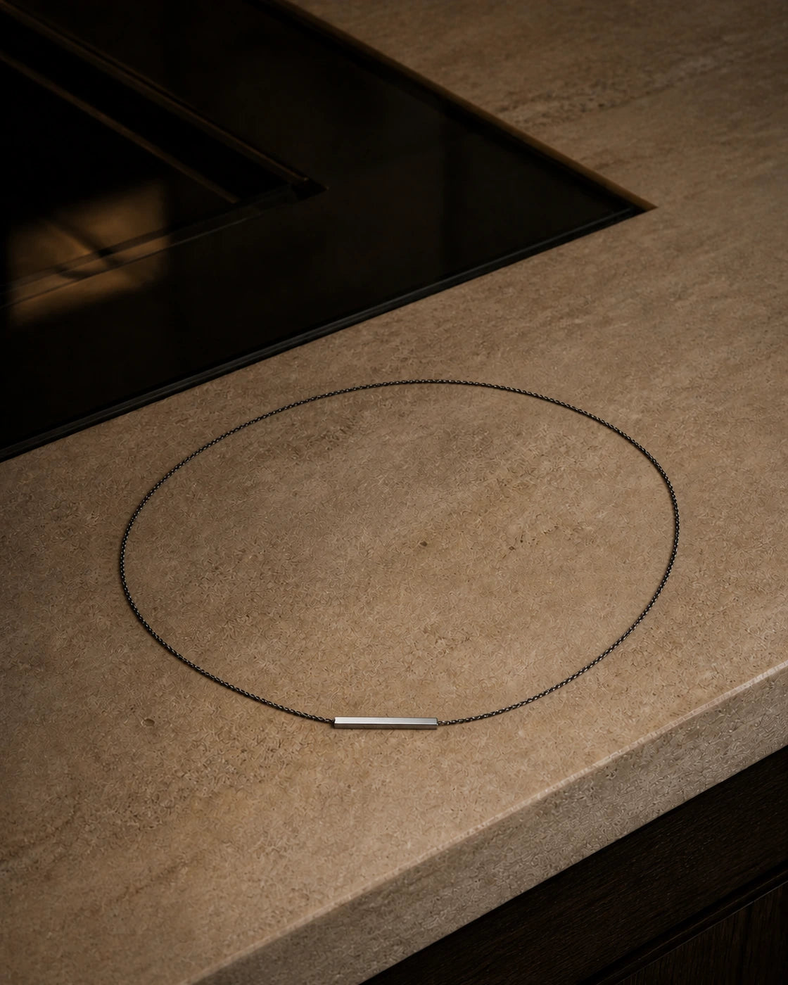 DARENZ Em Dash Chain still life on charcoal stone with dark timber and controlled evening light