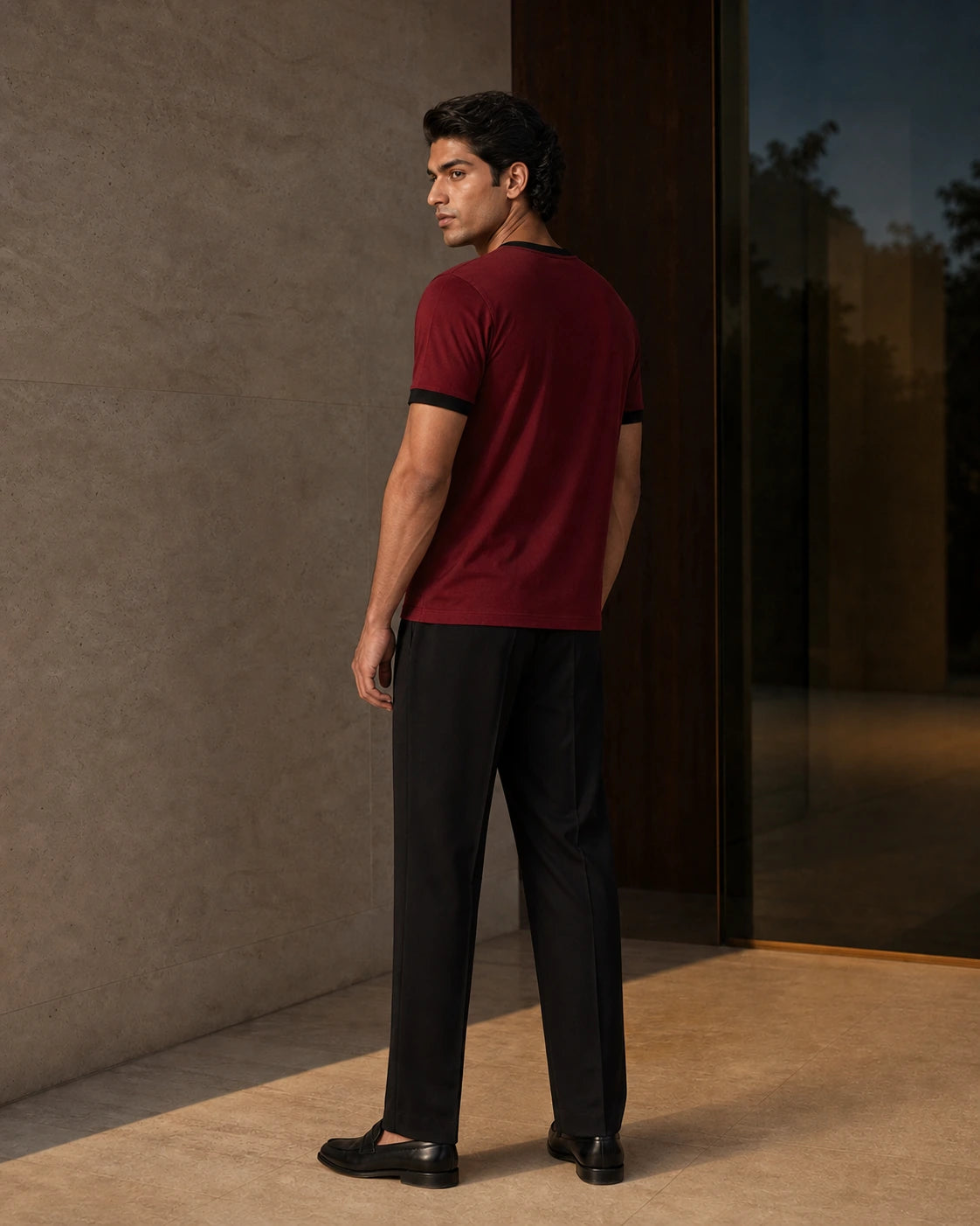 Side and back view of the Cardinal / Black DARENZ First Line Ringer Tee on its assigned model near smoked glass