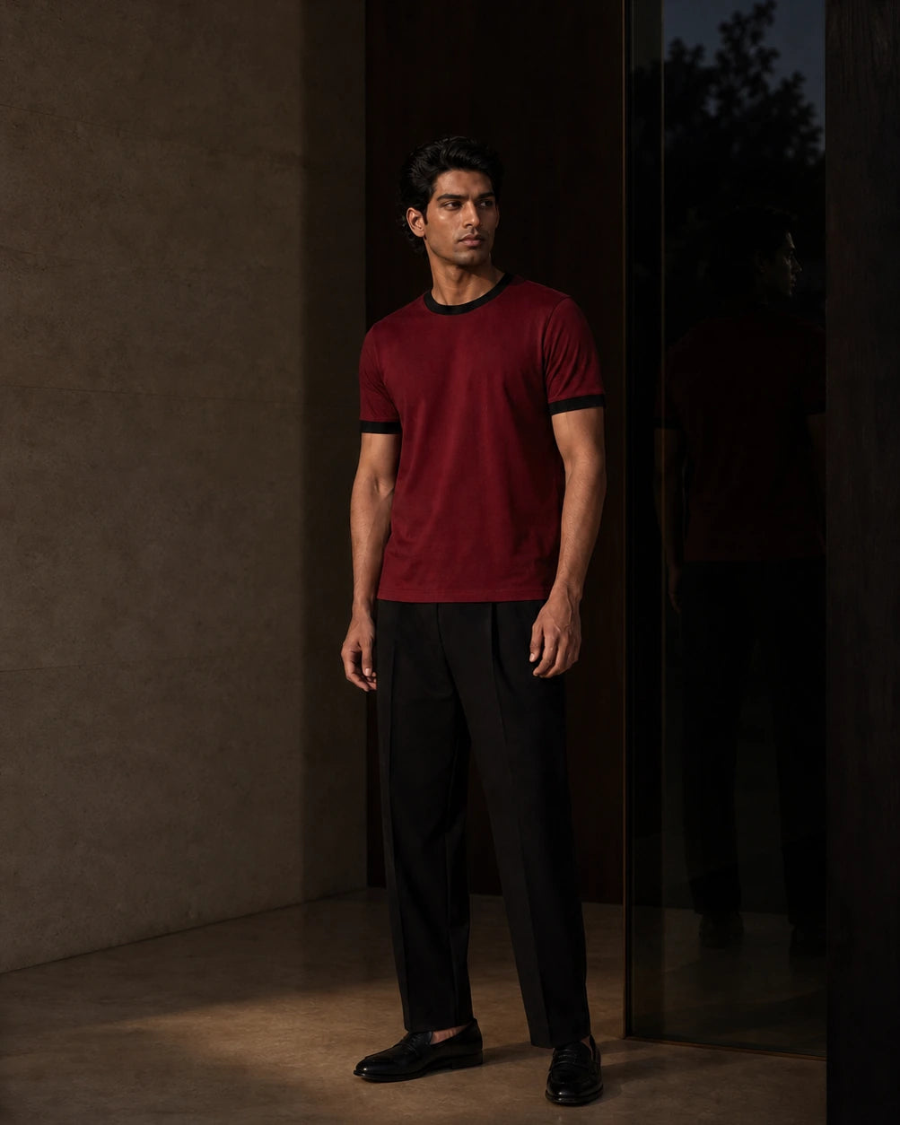 Between Lines chapter portrait featuring the Cardinal / Black DARENZ First Line Ringer Tee in a charcoal evening interior