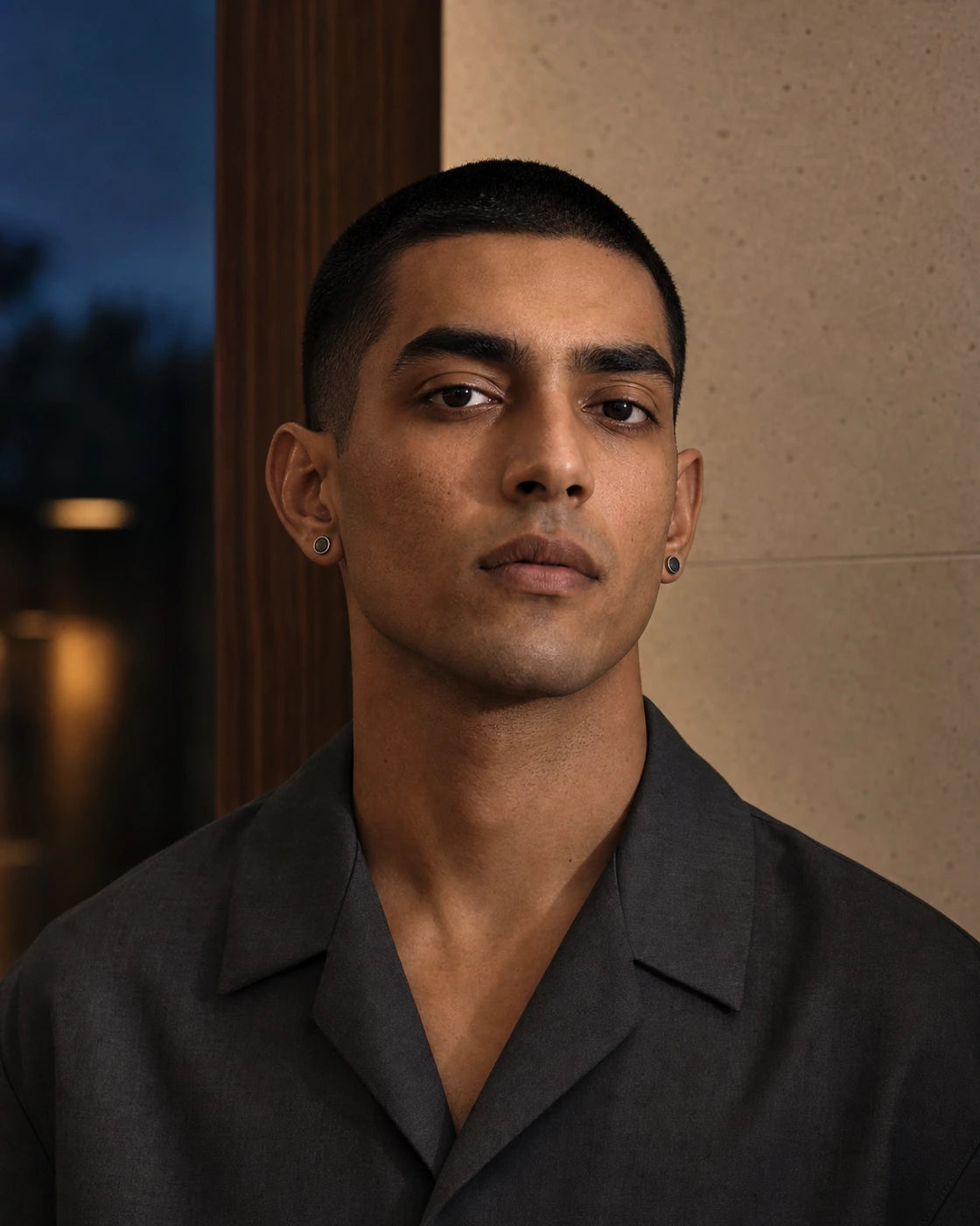 South Asian male model wearing the DARENZ Full Stop Stud Pair with blackened circular centres and polished rims