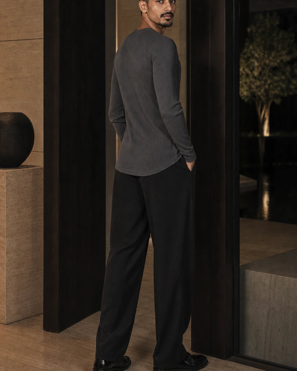Side and back view of the Graphite DARENZ Interval Long-Sleeve Henley on its assigned model near smoked glass
