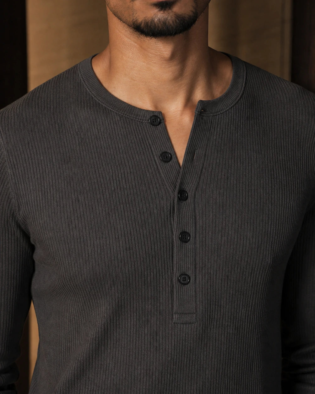 Close-up of the DARENZ Interval Long-Sleeve Henley in Graphite, showing the graphite ribbed jersey, tonal buttons and clean long-sleeve finish