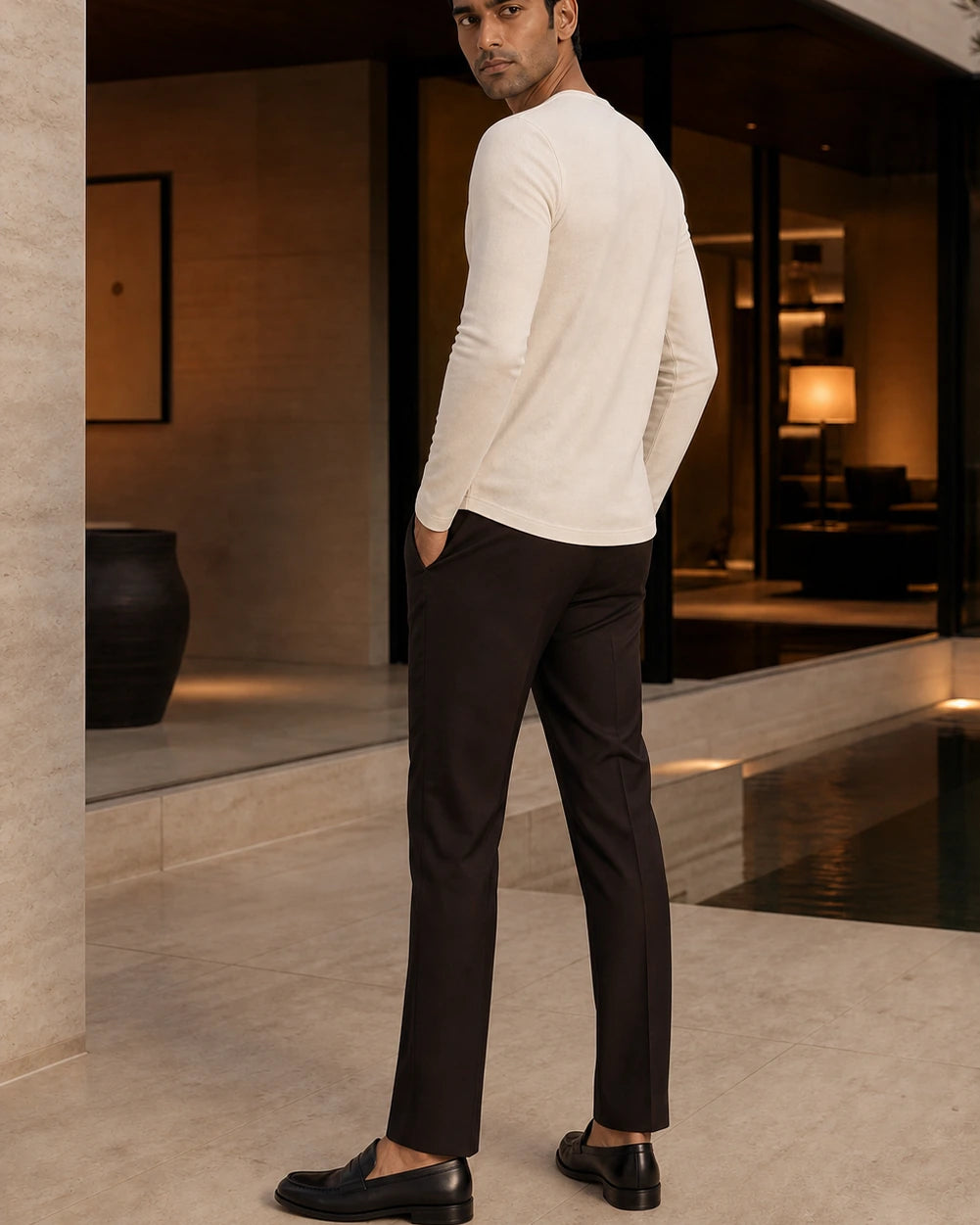 Side and back view of the Ivory DARENZ Interval Long-Sleeve Henley on its assigned model near smoked glass