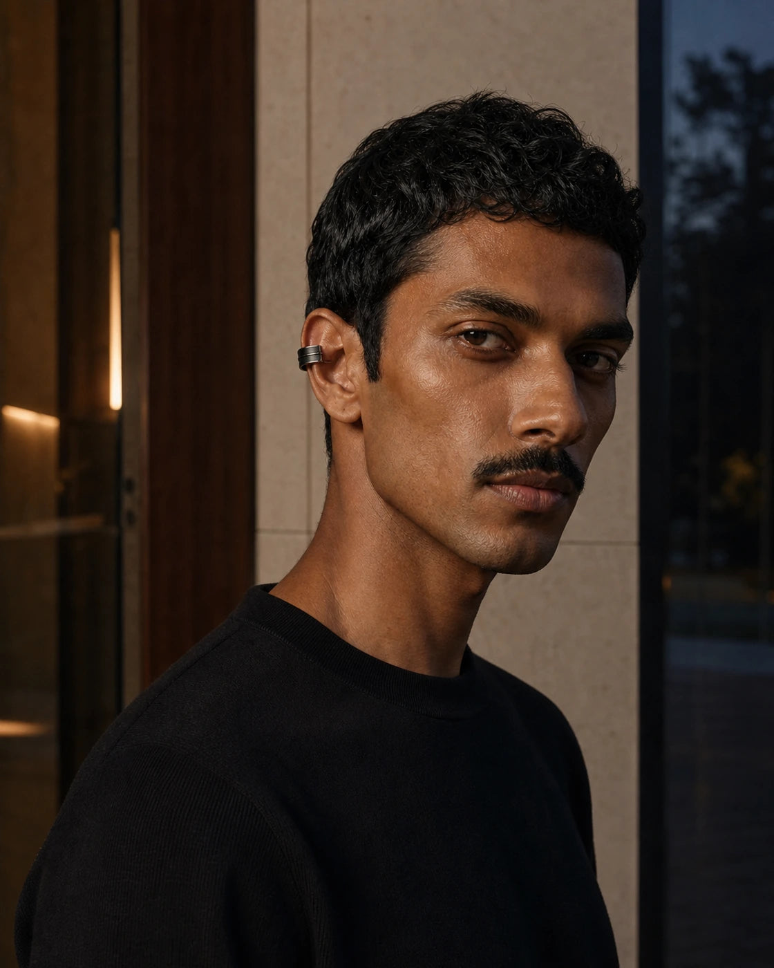 Alternate on-body view of the DARENZ Margin Ear Cuff, showing its blackened steel finish against evening tailoring