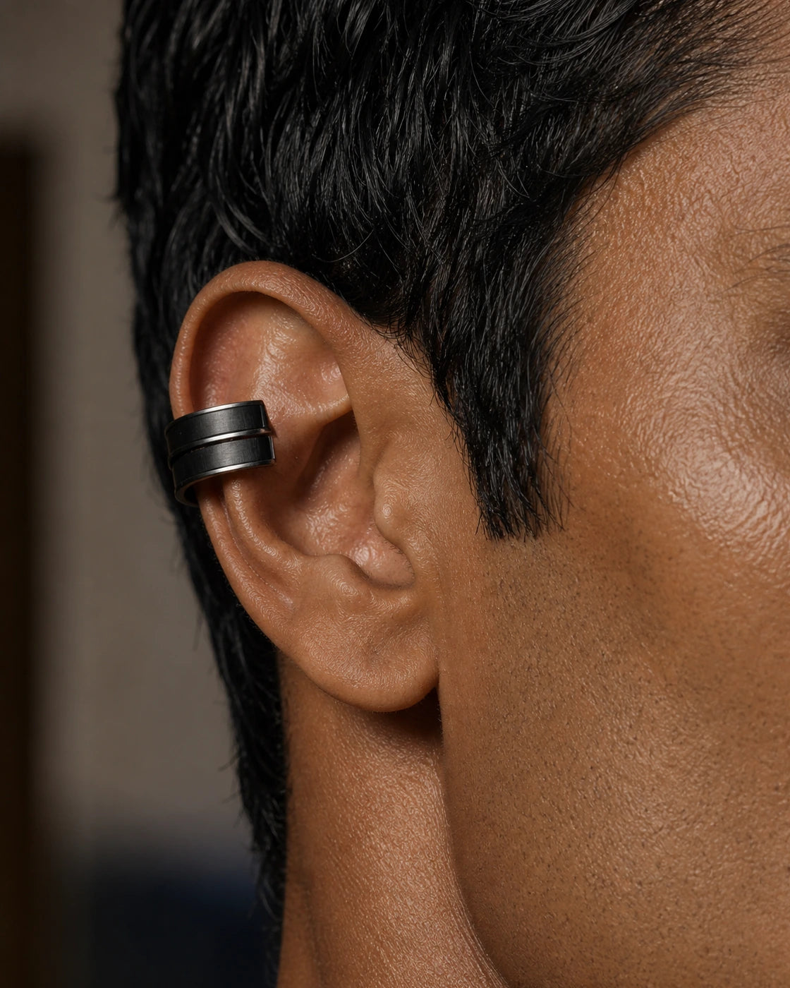 Macro photograph of the DARENZ Margin Ear Cuff, revealing the parallel double-line profile, open back and satin blackened finish