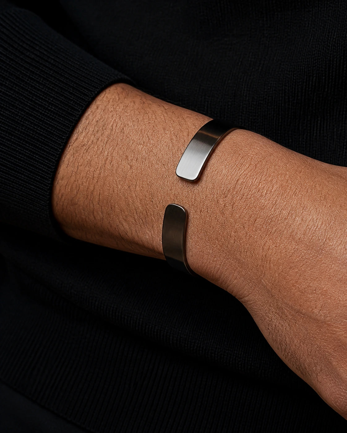 Macro photograph of the DARENZ Parenthesis Cuff, revealing its offset terminals, dark outer plane and polished inner curve